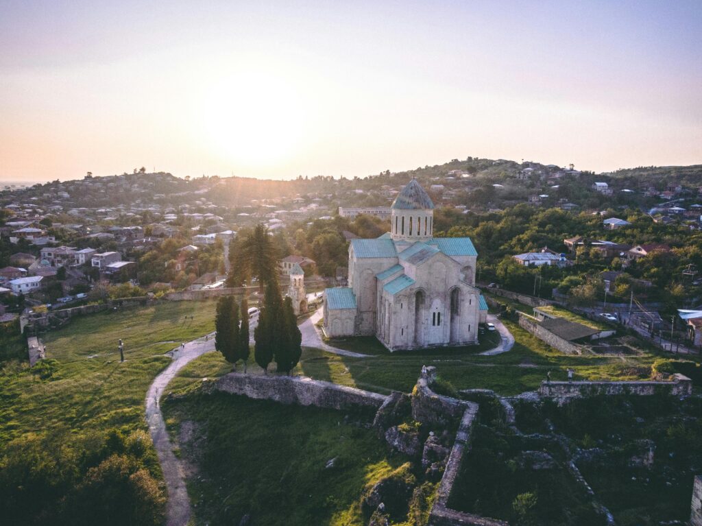 Aerial view of Bagrati Cathedral in Kutaisi, Georgia, showcasing stunning landscape at sunrise.