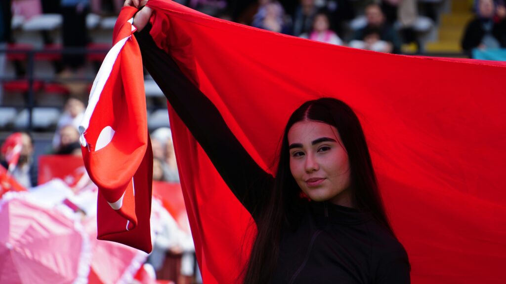 A young woman proudly waves the Turkish flag during a national celebration in Istanbul.