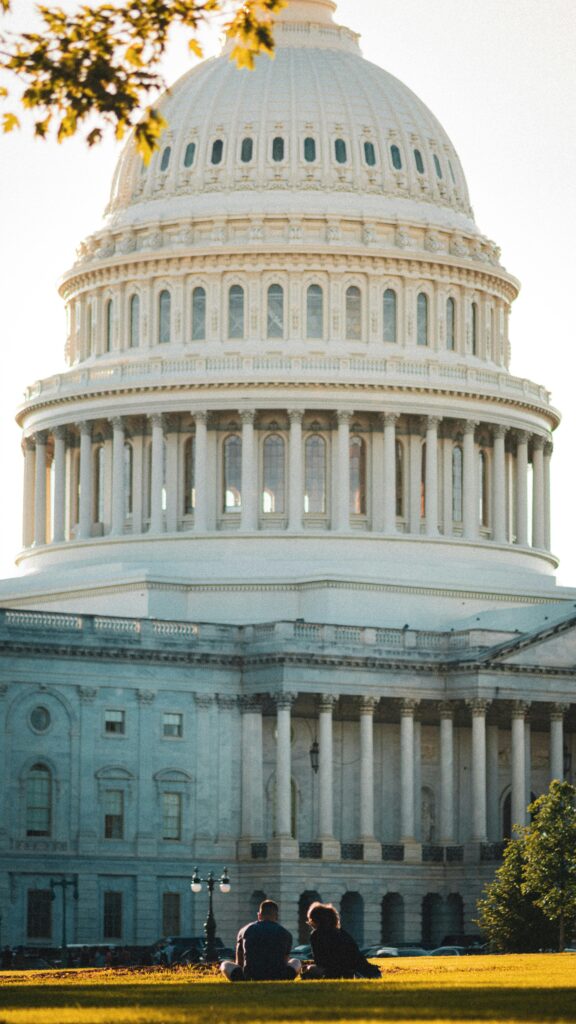 A couple enjoys a sunny day on the lawn in front of the iconic US Capitol in Washington, DC.