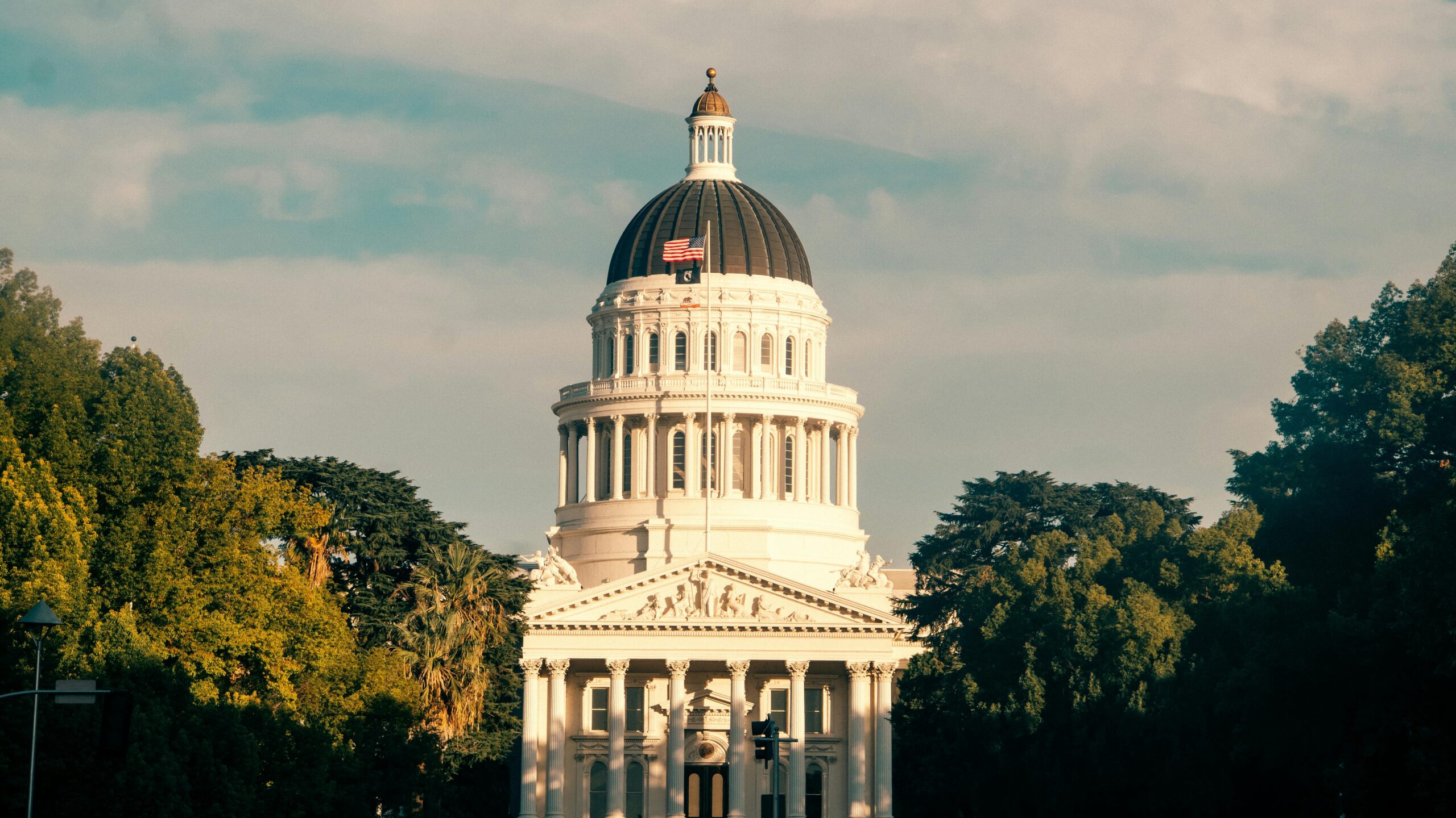 Captivating view of the California State Capitol amidst lush greenery under a clear sky.