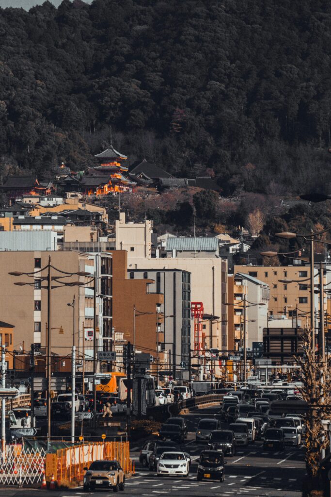 A vibrant view of Kyoto streets with Kiyomizu-dera temple nestled in lush hills.