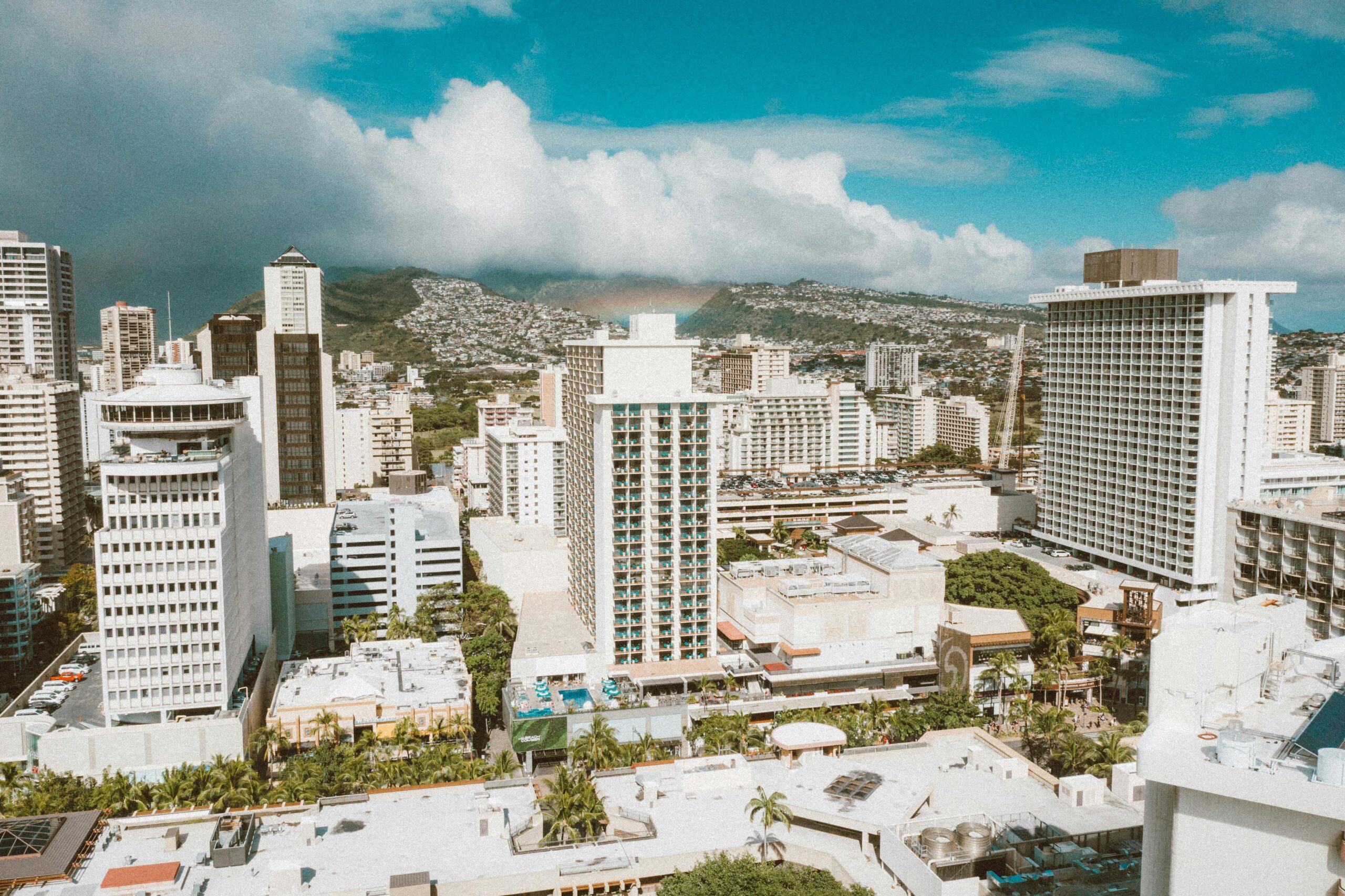 A vibrant aerial view of Waikiki in Honolulu showcasing the skyline against lush mountains.