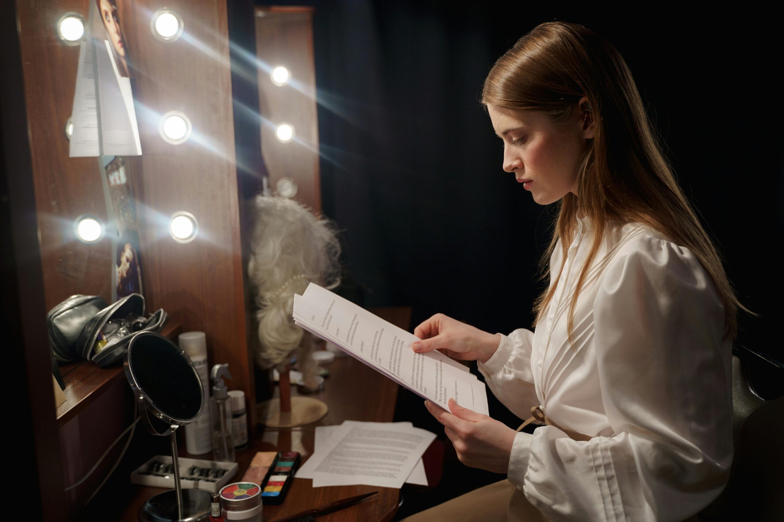 An actress reviews her script in a glamorous dressing room setting, full of anticipation.