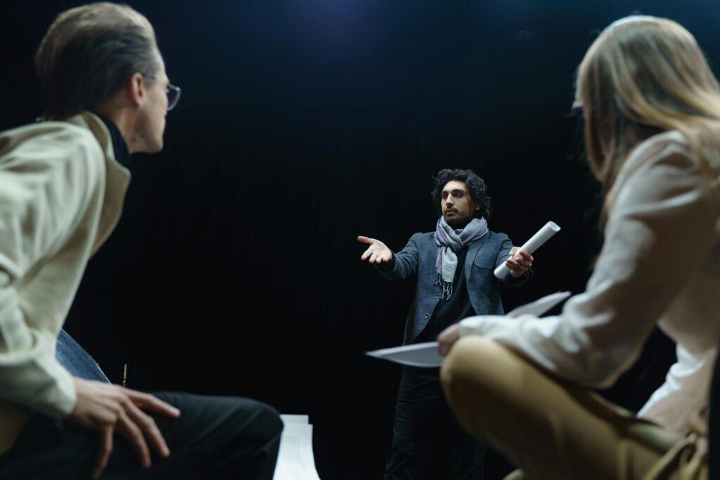 Theater director guides actors in an intense rehearsal scene on stage.