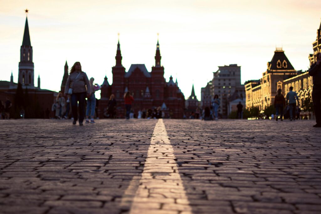 Silhouettes on Red Square's cobblestones against a beautiful twilight sky in Moscow.