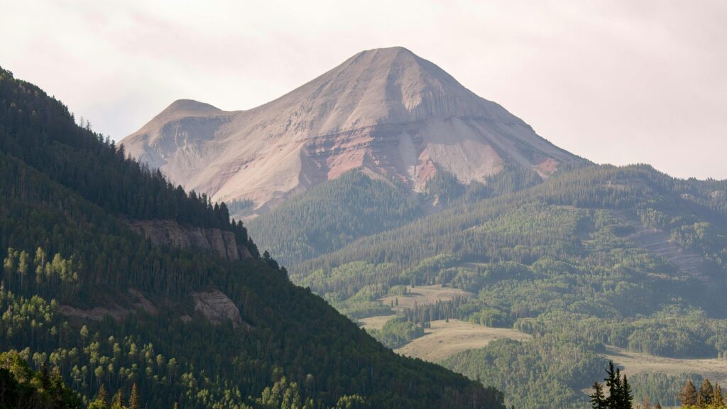 Breathtaking view of Engineer Mountain surrounded by lush forests in Colorado's landscape.