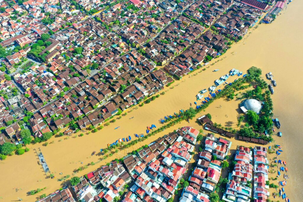 A striking aerial view of floodwaters in Hội An, Việt Nam, showcasing the city's streets and buildings submerged.