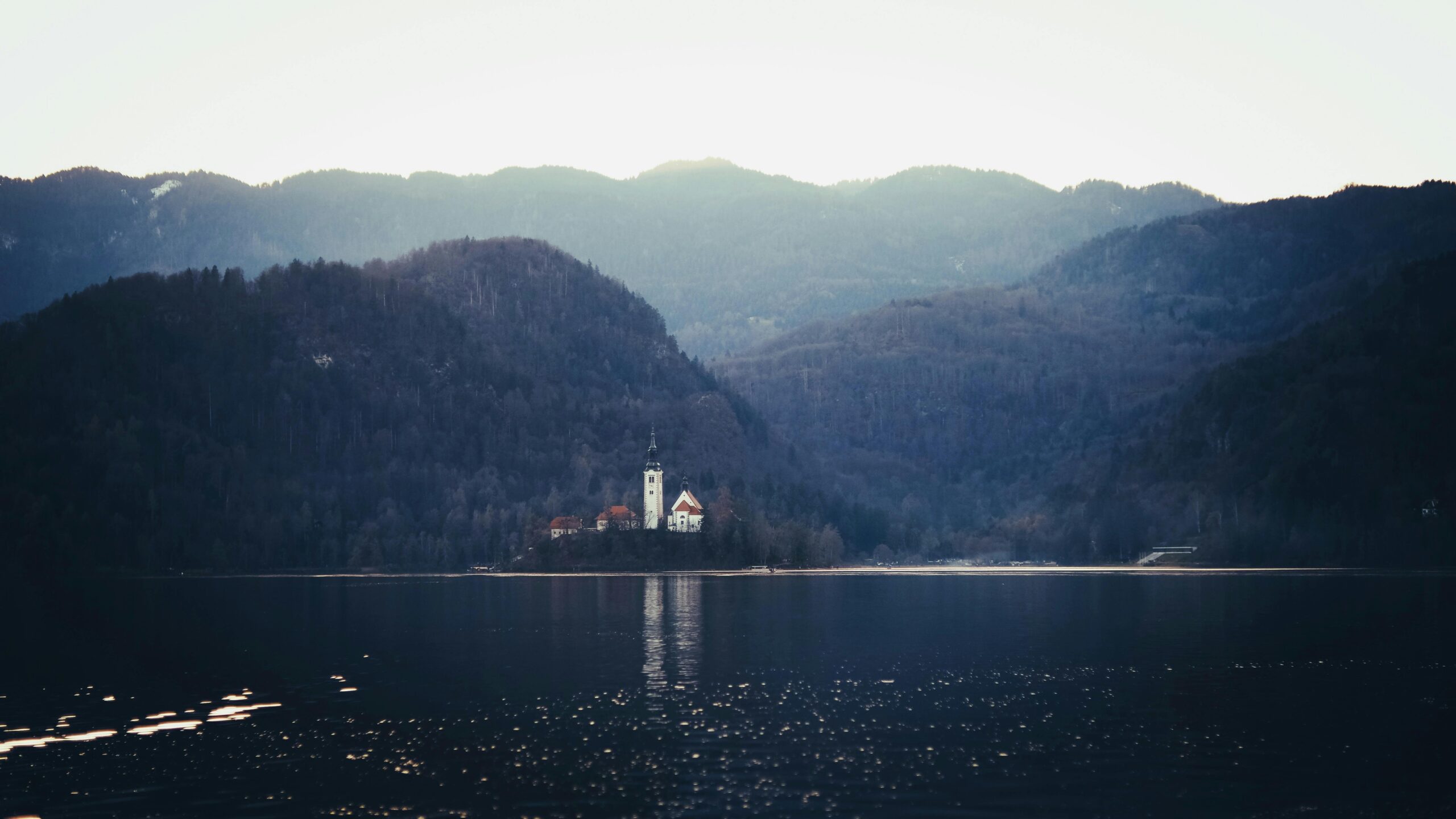 Captivating view of Lake Bled with church and hills in tranquil Slovenia setting.