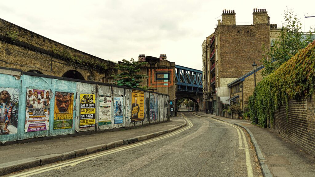 Empty street in London with colorful posters and historic architecture.