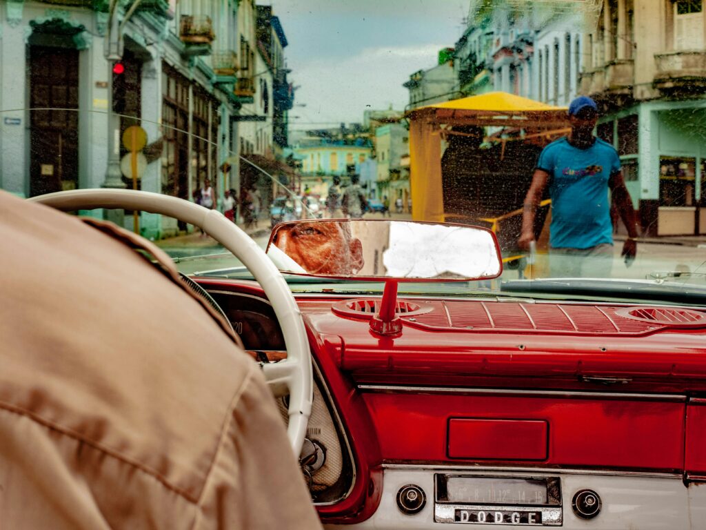 View from inside a classic car driving through bustling Havana, Cuba street.
