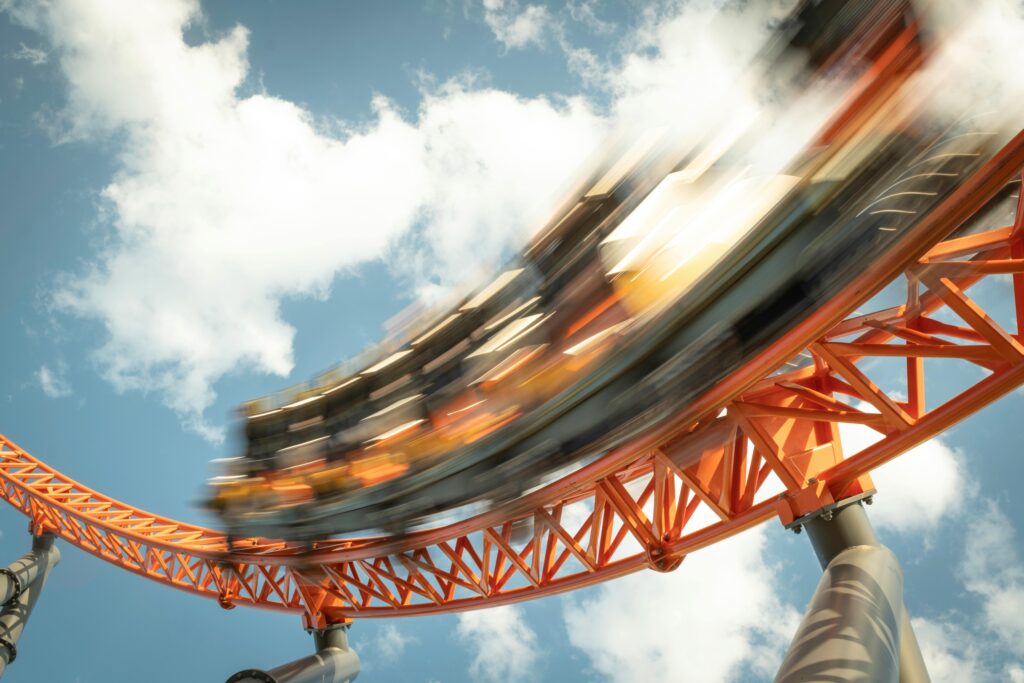 Exciting roller coaster ride with motion blur against a bright sky backdrop.