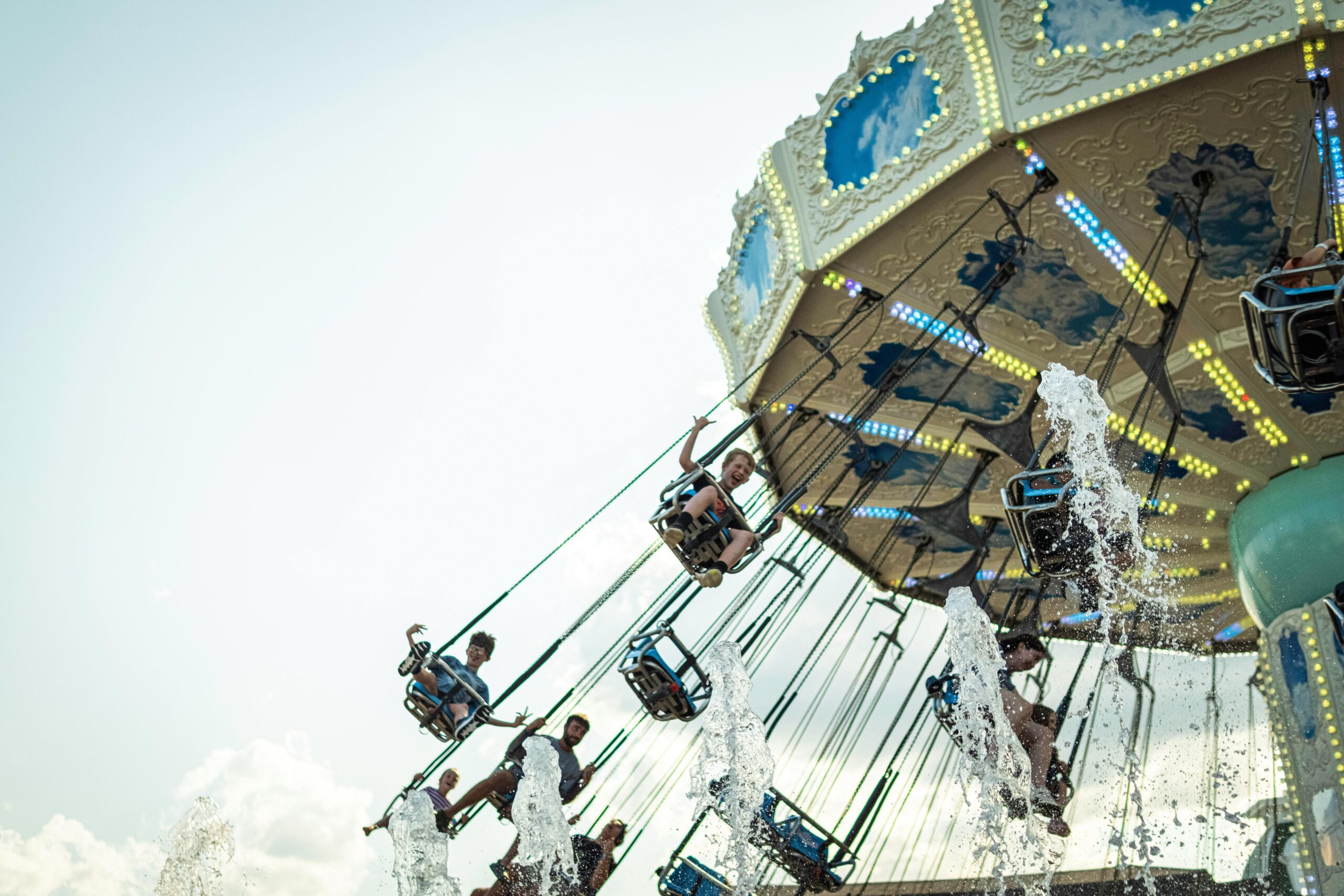 Exciting aerial swing ride at theme park, perfect for thrill-seekers captured in action on a sunny day.