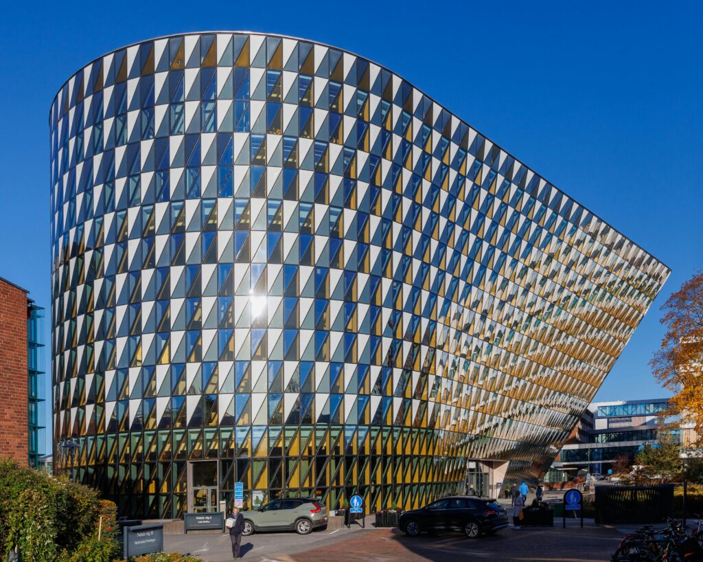 Modern architecture of Aula Medica at Karolinska Institute, Stockholm under a clear blue sky.