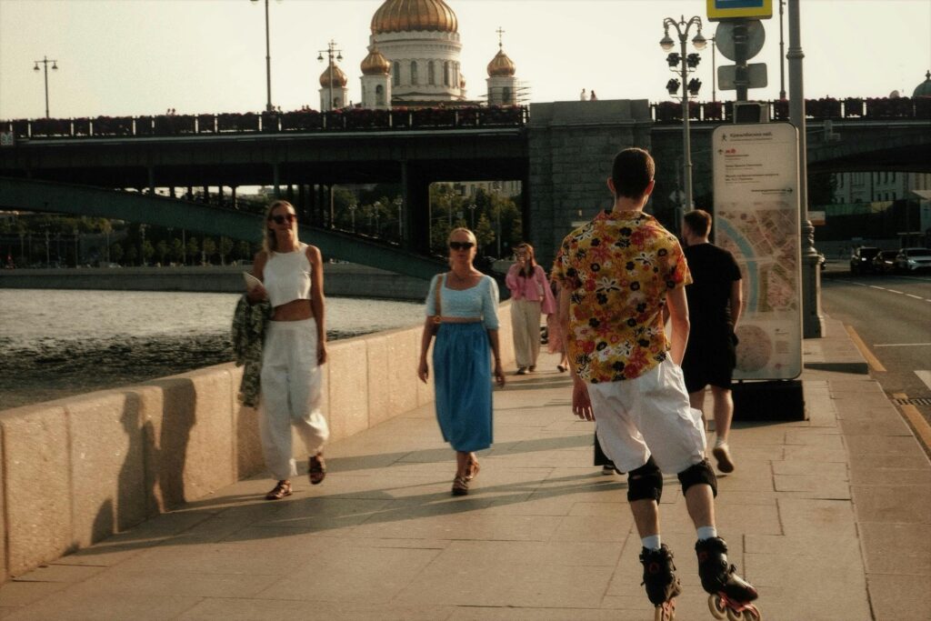 Casual stroll along riverside promenade with iconic bridge and cathedral in view.