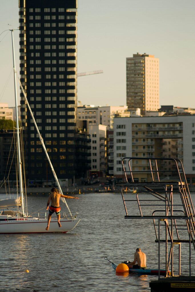 Enjoying water sports and diving in Stockholm as the sun sets behind city buildings.