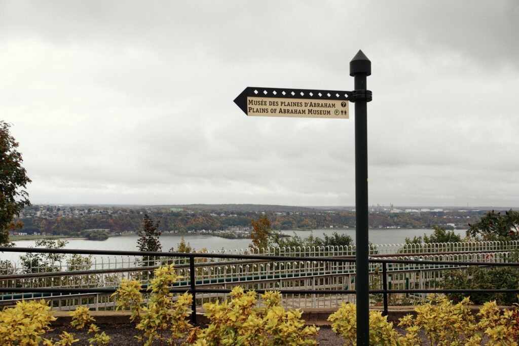Scenic view of the Plains of Abraham in Quebec City during autumn with a directional sign.