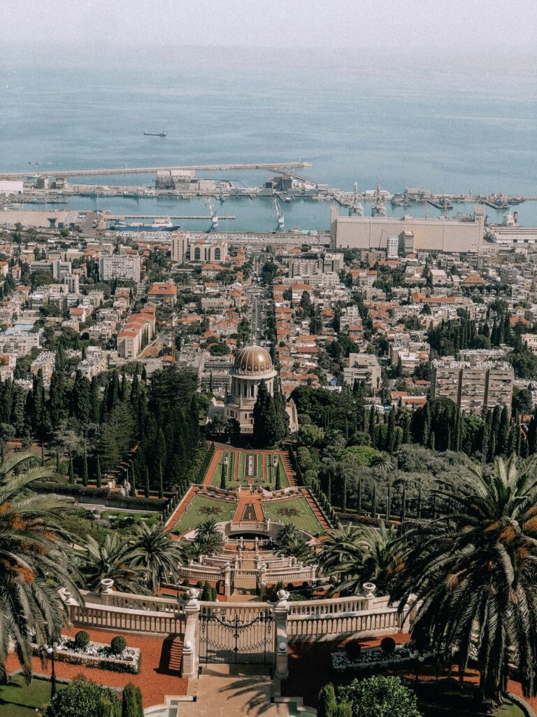 A stunning aerial shot of the Bahai Gardens in Haifa with the cityscape and harbor backdrop.