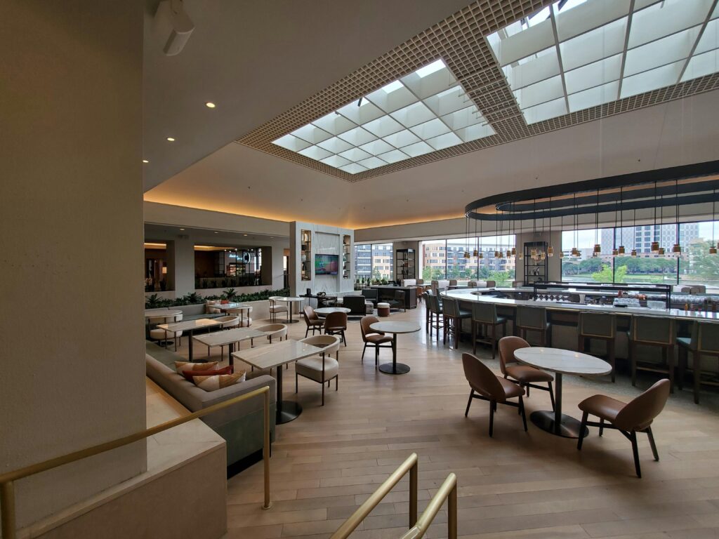 Spacious and elegant hotel bar with modern decor and open seating in Irving.