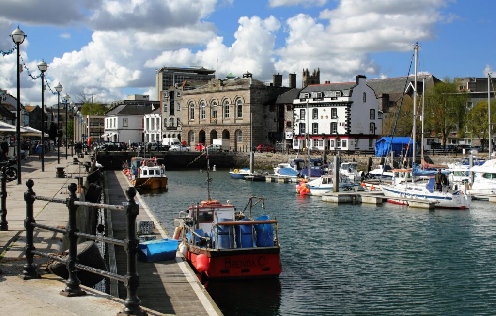 A picturesque harbour with boats and historic buildings on a sunny day.