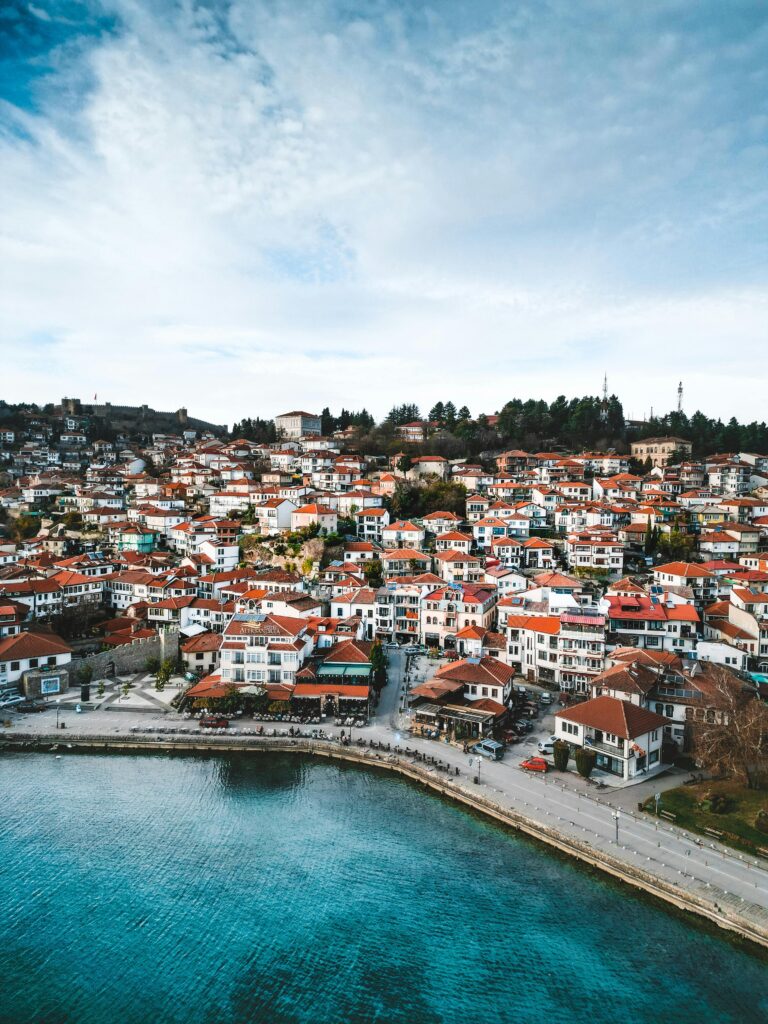 Explore the charming rooftops and coastline of a picturesque European town from above.