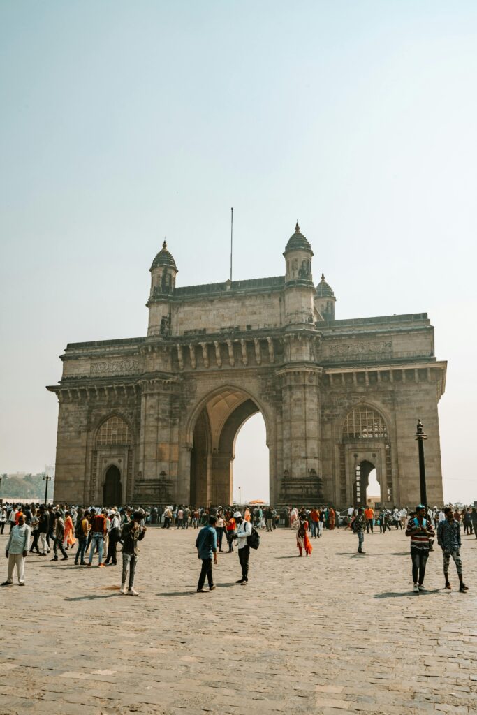 Iconic Gateway of India with tourists, a landmark in Mumbai, India symbolizing historic architecture.