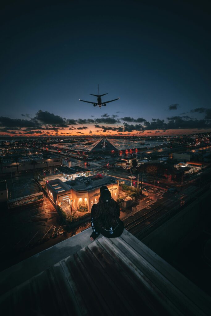 Captivating view of an airplane flying over the vibrant San Diego cityscape during a beautiful sunset.