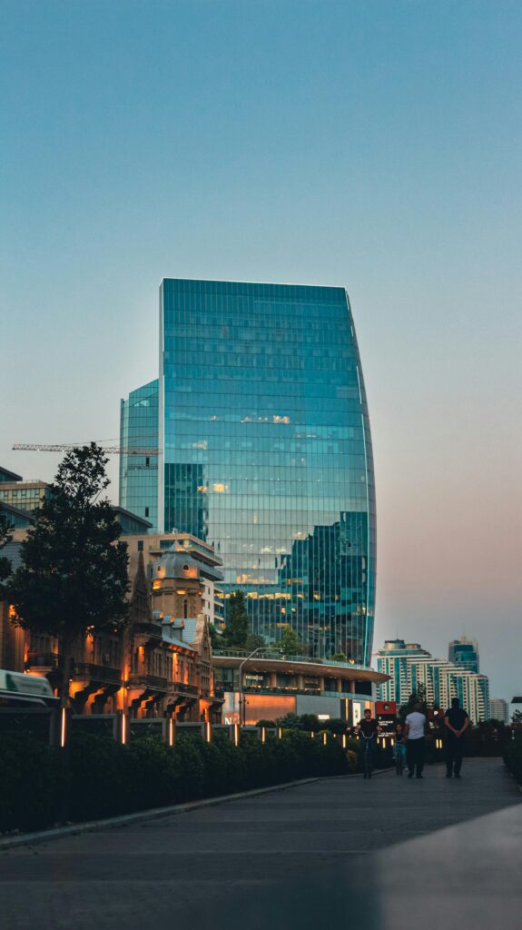 Modern skyscraper in Baku, Azerbaijan, reflecting cityscape at twilight.