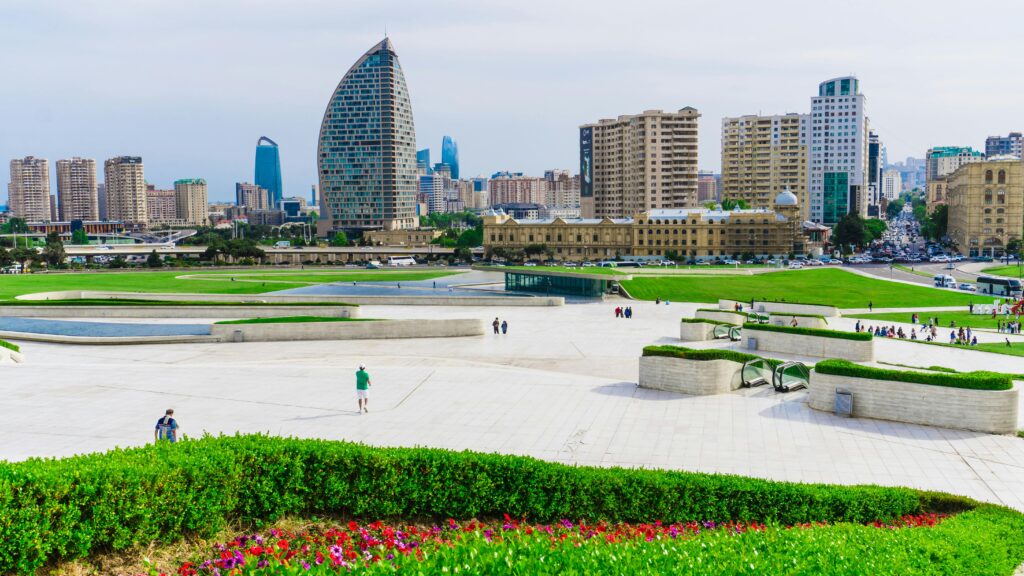Panoramic view of Baku's modern skyline with iconic architecture and lush greenery.