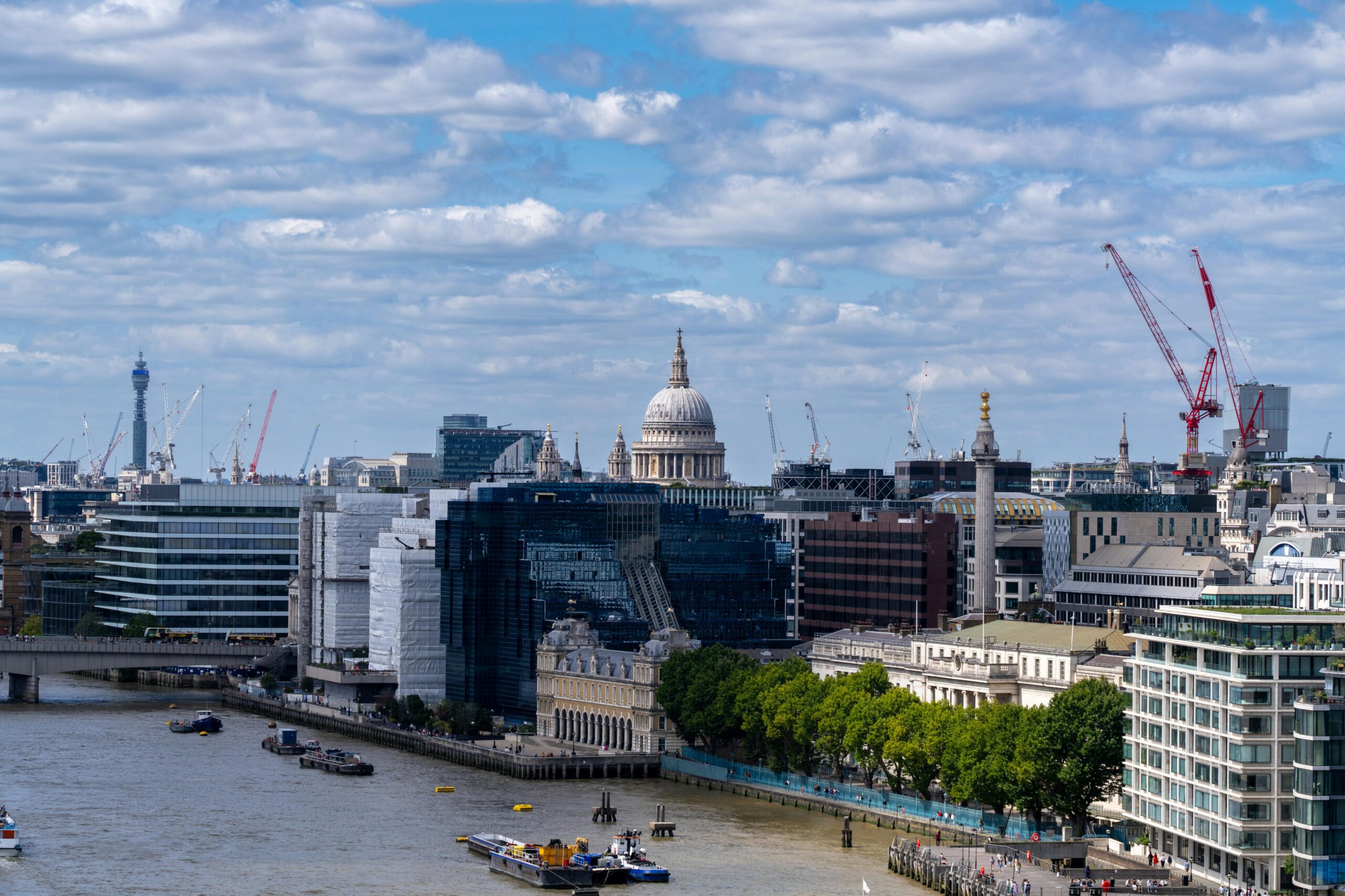 A stunning view of London's skyline with St Paul's Cathedral and the River Thames on a bright day.