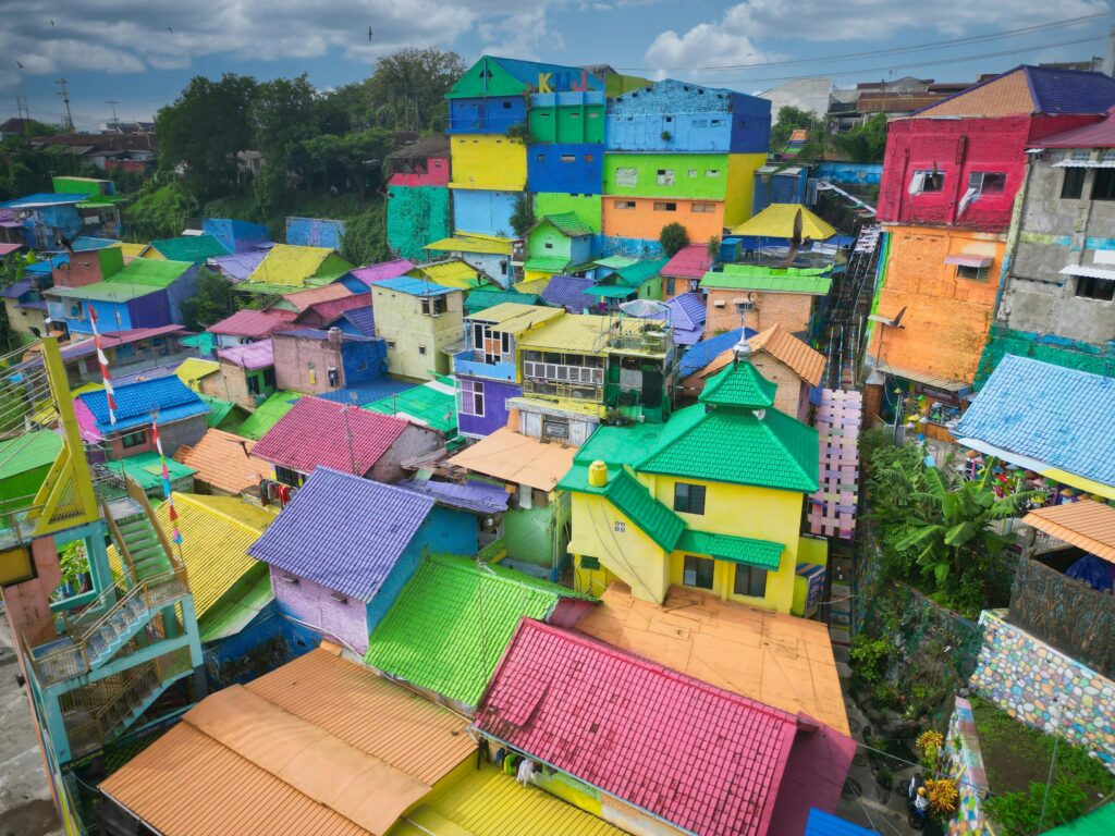 Colorful aerial view of Rainbow Village in Malang, Indonesia showcasing vibrant houses and rooftops.