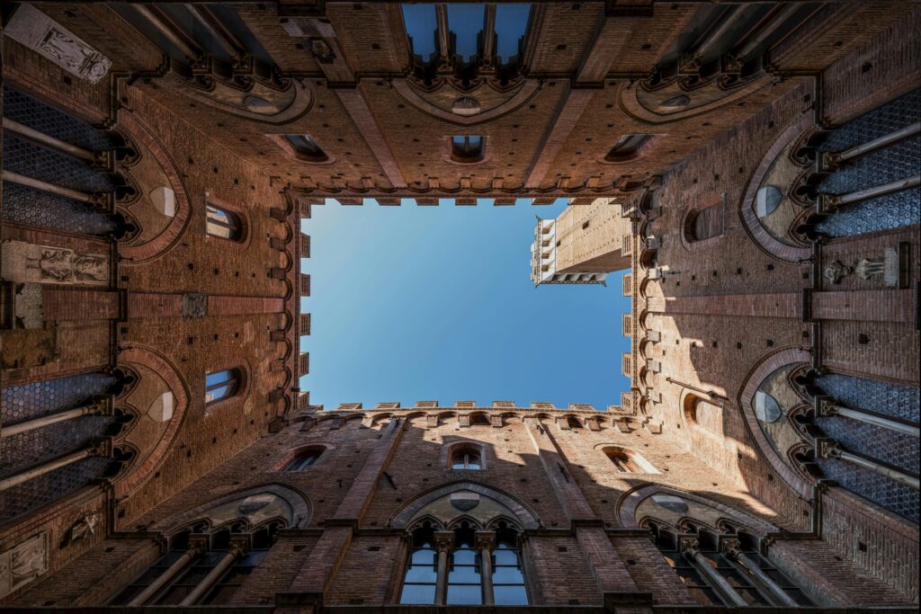 Stunning upward view of the Palazzo Pubblico courtyard in Siena, Italy.