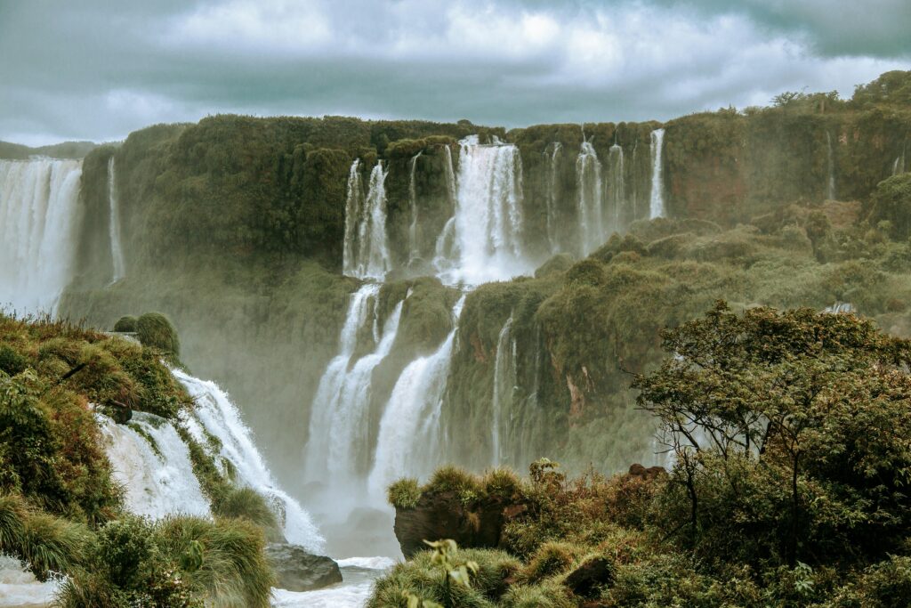 Breathtaking view of Iguazu Falls in Brazil, surrounded by vibrant rainforest and mist.