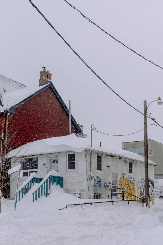 Charming urban house blanketed in snow, showcasing winter's beauty in the city.