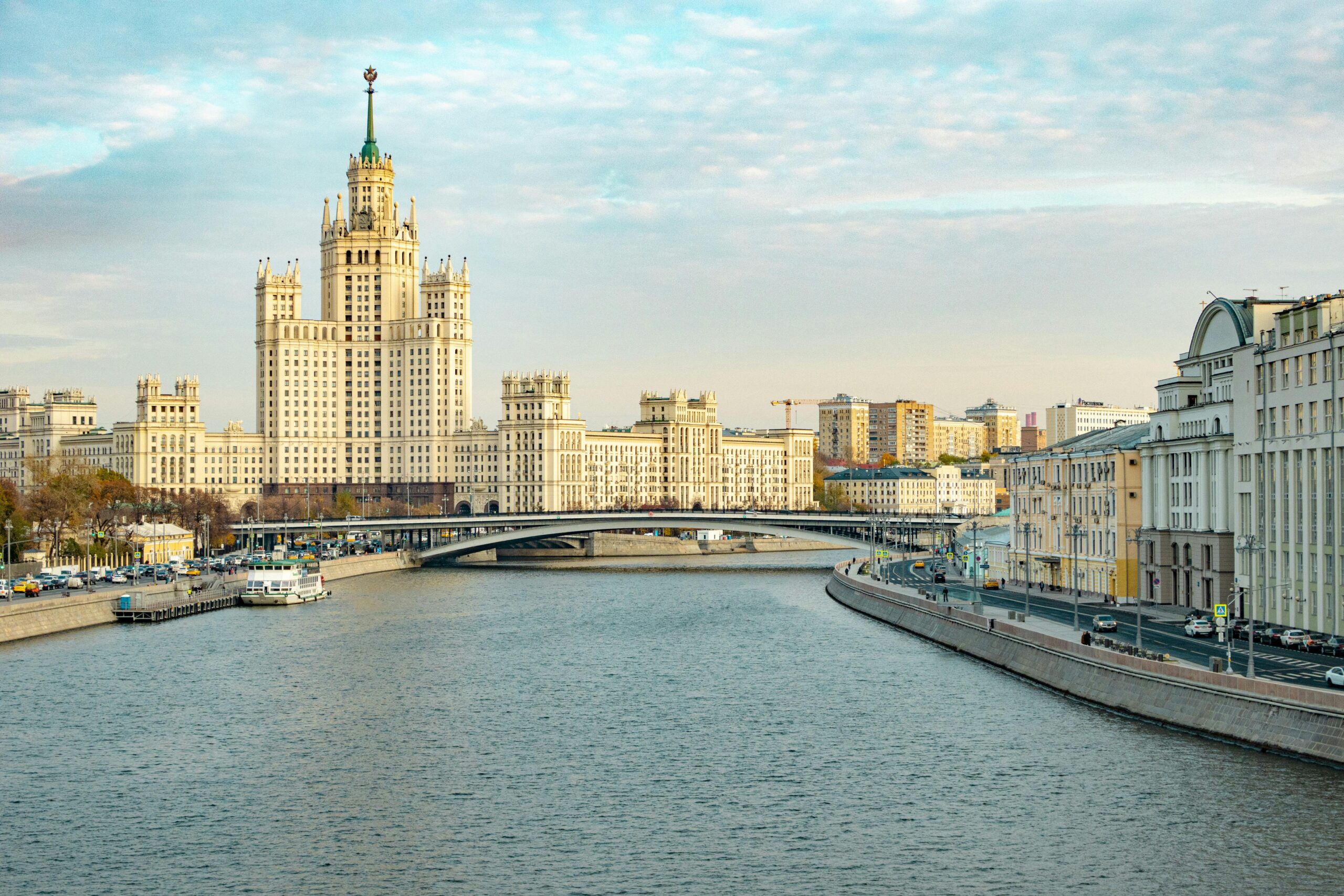 A view of Stalinist architecture by the Moscow River under a clear sky.