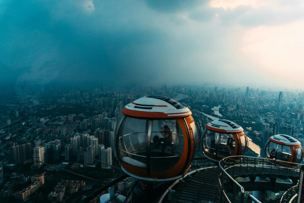 A stunning view of an observation wheel with scenic cityscape below, showcasing urban architecture and futuristic design.