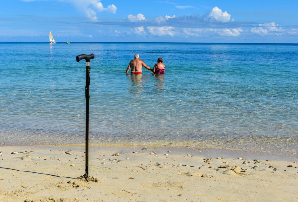 A senior couple enjoying the warm waters of Playa Jibacoa in Cuba, symbolizing love and relaxation.