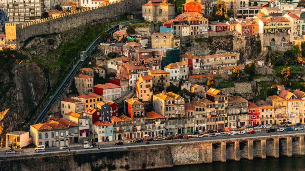 Aerial view of historic buildings on a hillside in Porto, Portugal, showcasing vibrant architecture and urban landscape.