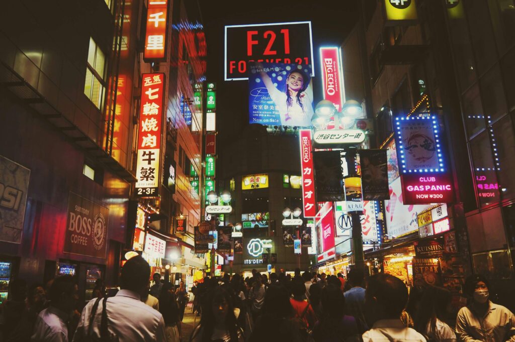 Explore the vibrant energy and bustling nightlife of Tokyo's iconic shopping districts, illuminated by colorful billboards.