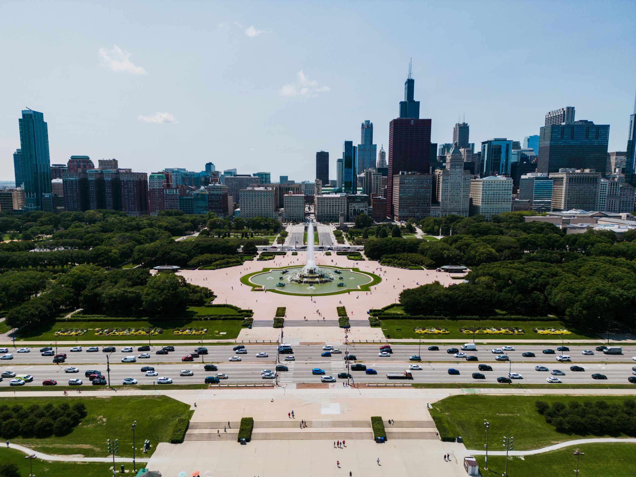 Aerial view of Buckingham Fountain with Chicago skyline in the background, vibrant summer day.