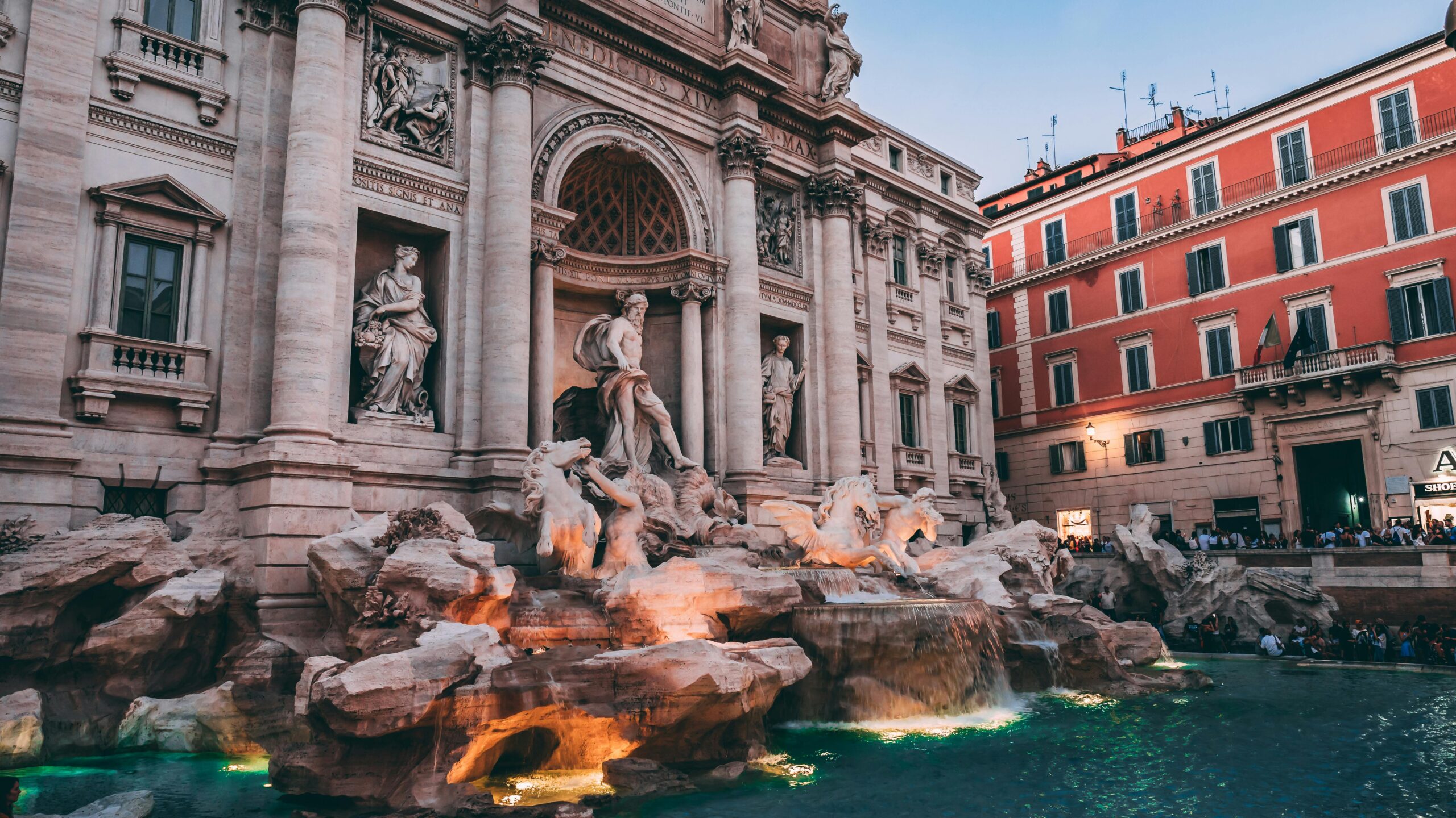 The iconic Trevi Fountain in Rome, a masterpiece of Baroque architecture, captured at dusk.