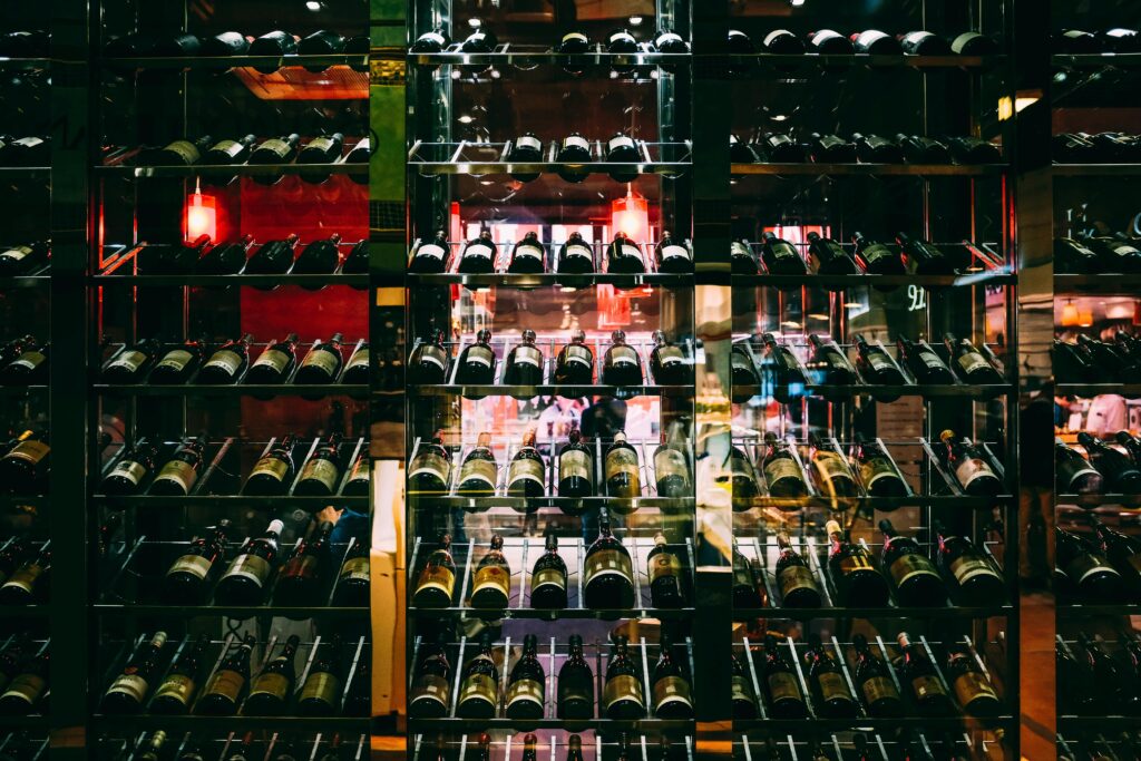 Rows of wine bottles elegantly displayed on shelves at an upscale bar, creating a luxurious ambiance.
