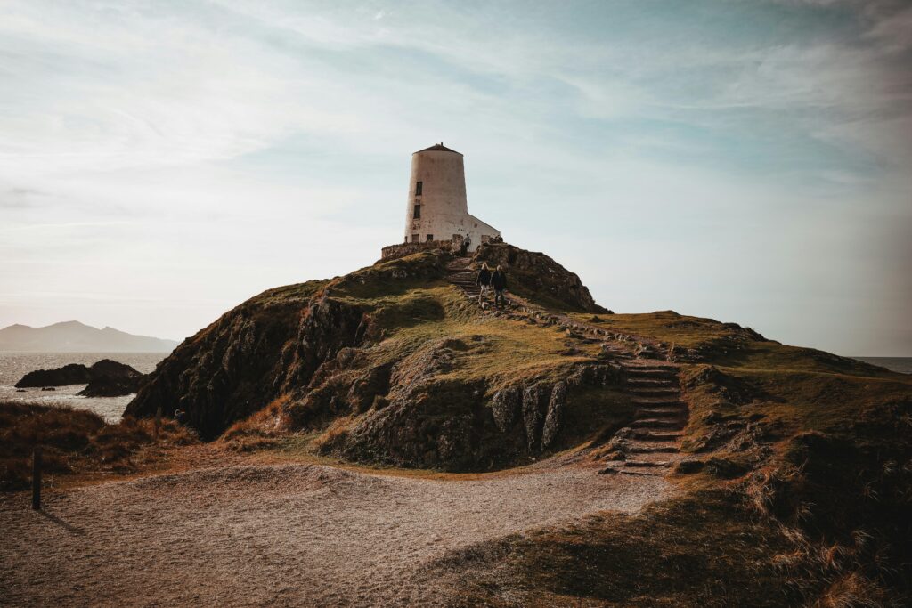 Explore the scenic beauty of Llanddwyn Island with its iconic lighthouse and rugged landscape.