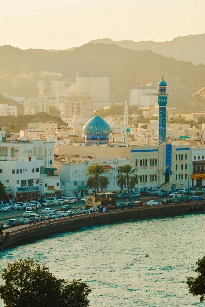 Stunning landscape of Muttrah Corniche with mosque and mountains in Muscat, Oman.