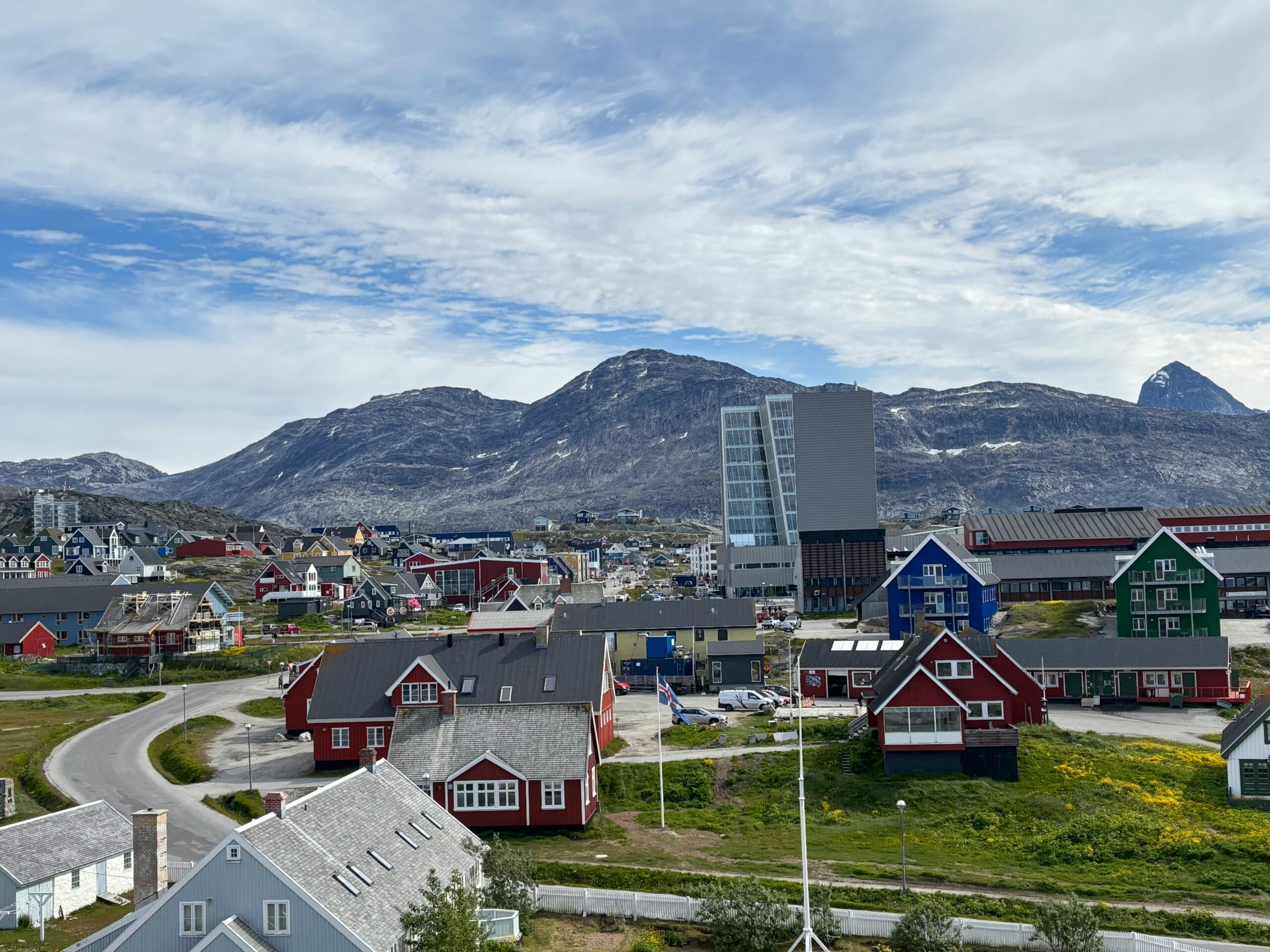 A picturesque view of Nuuk with colorful buildings against a mountainous backdrop.