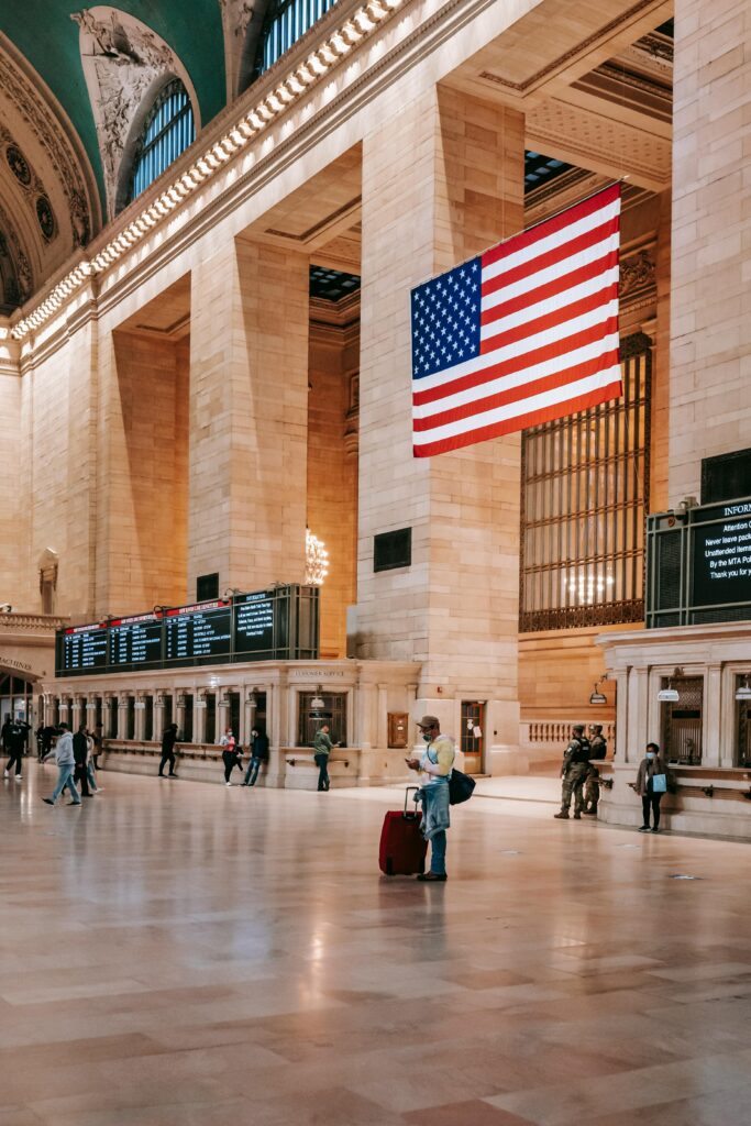 Interior of Grand Central Terminal featuring the American flag and elegant architecture.