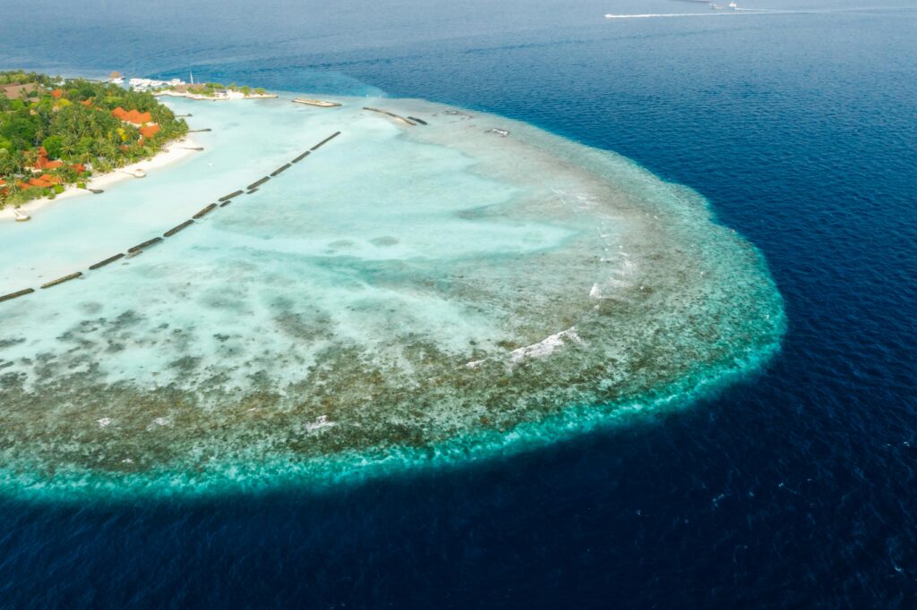 Stunning aerial view of a tropical island lagoon with vibrant blue waters and coral reefs.