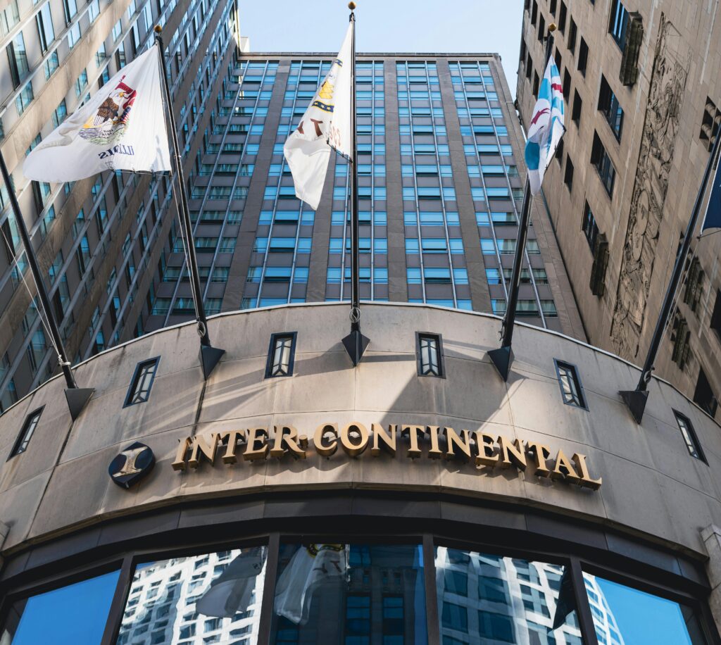 Low angle shot of InterContinental Hotel in Chicago, showcasing architectural design and flags.