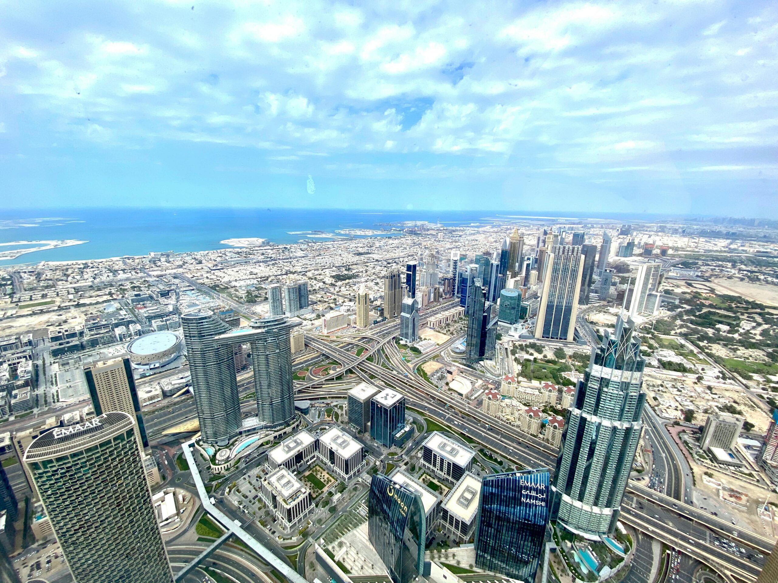 Stunning aerial view of Dubai's skyline, featuring skyscrapers and the sea.