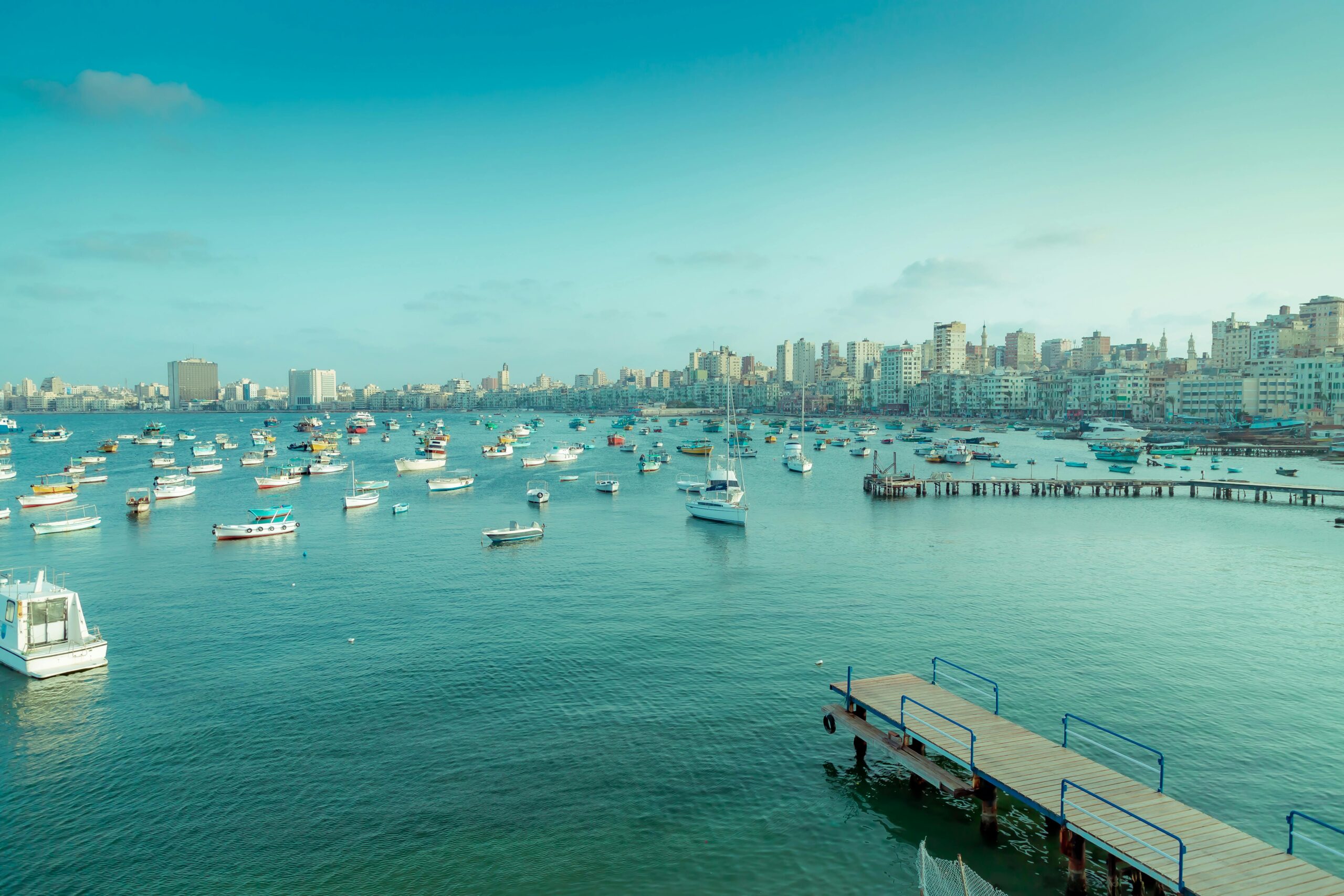 A stunning view of Alexandria's harbor featuring boats, piers, and the city skyline.