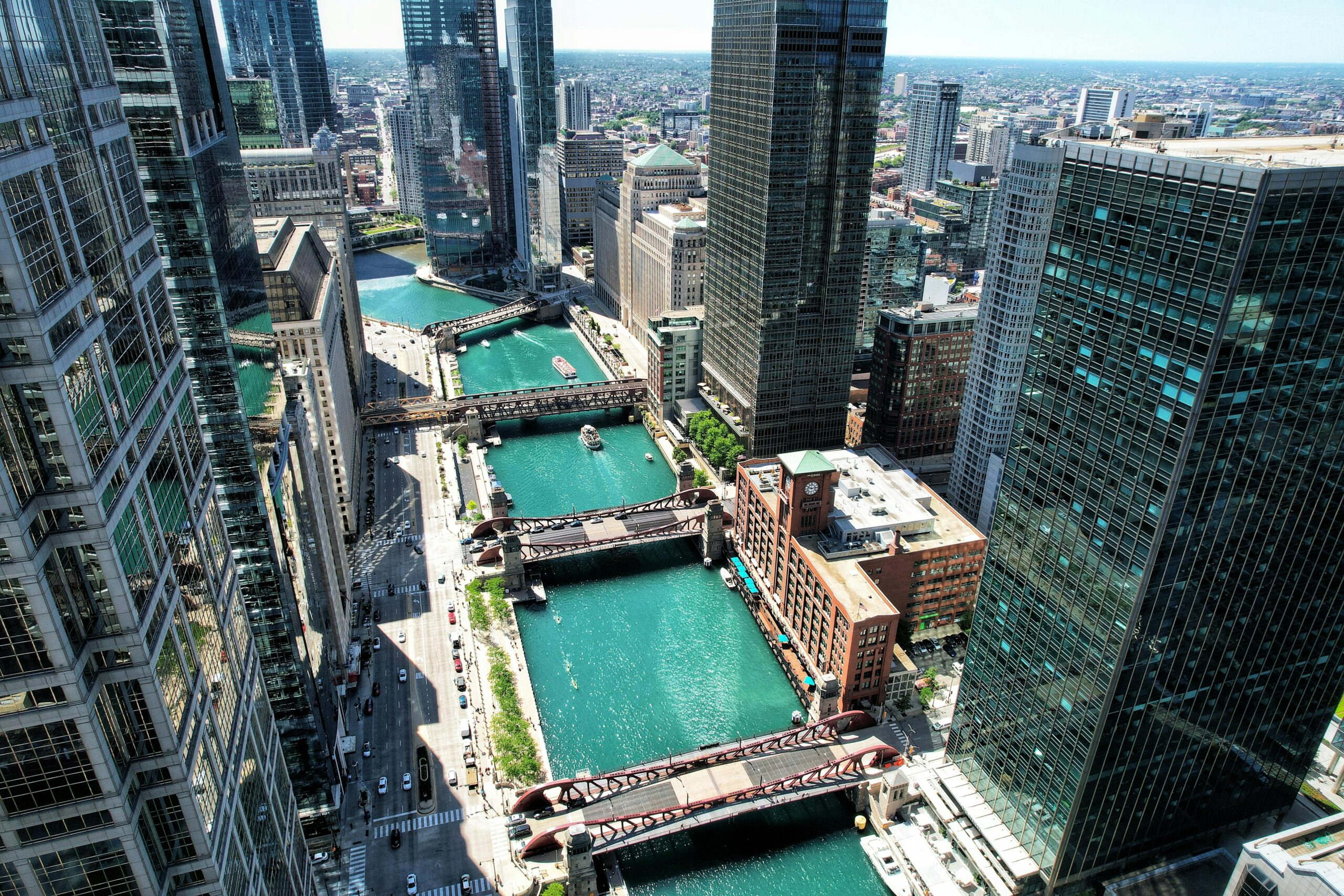 A stunning aerial shot of the Chicago River amidst skyscrapers on a clear day.